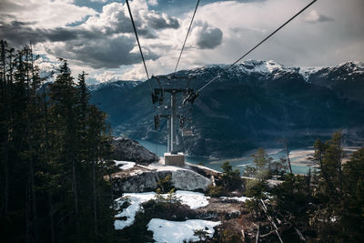 Overhead cable car on snowcapped mountains against sky