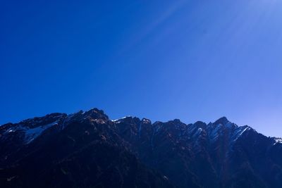 Low angle view of mountains against clear blue sky