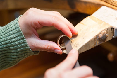 Close-up of human hand holding wood