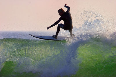 Side view of man in sea against sky