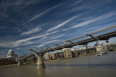 Bridge over river against cloudy sky