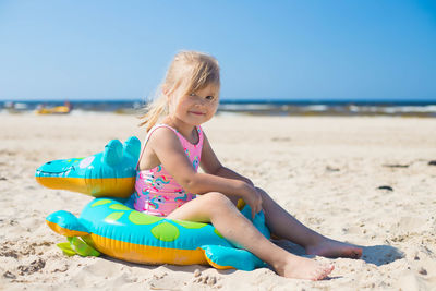 Portrait of young woman sitting at beach