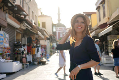 Young woman discovering rhodes city on sunset with mosque of suleiman on the background, greece