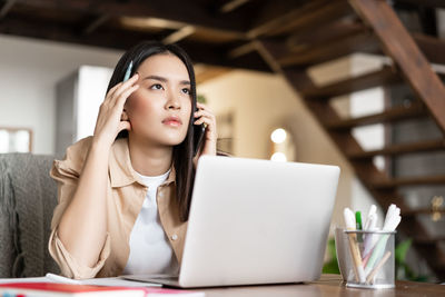 Young woman using laptop at home