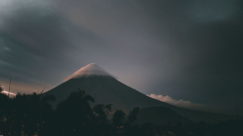 Scenic view of snowcapped mountains against sky . the mayon volcano under umbrella clouds