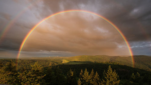 Scenic view of rainbow over field against sky