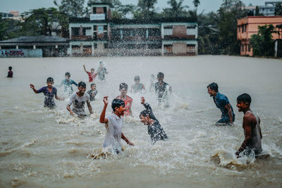 Full length of men playing in water