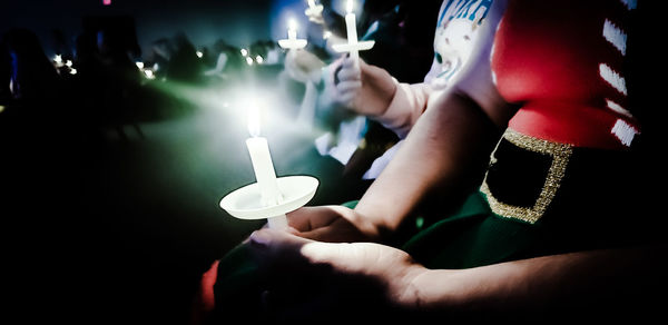 Midsection of woman holding illuminated lighting equipment