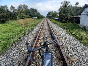 Railroad track amidst trees against sky