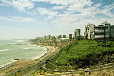High angle view of beach and buildings against cloudy sky