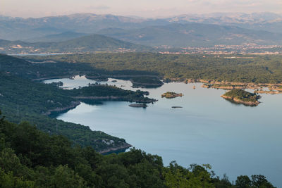 High angle view of lake and mountains against sky