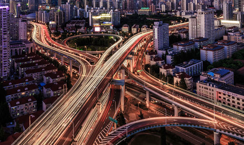 Light trails on bridges amidst cityscape