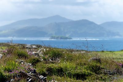 Scenic view of sea and mountains against sky