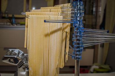 Raw pasta hanging on structure at kitchen