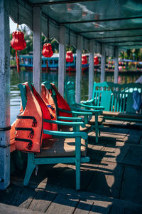 Empty chairs hanging on footpath