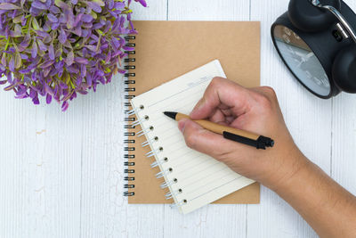 High angle view of person hand holding book on table