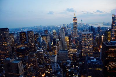 Illuminated cityscape against sky at dusk