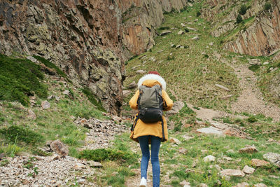 Rear view of woman standing on rock