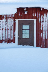 Snow covered house against building