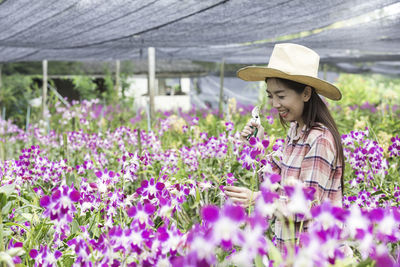 Asian farmers are planting orchids. gardener asian woman. cutting orchid in an orchid garden.