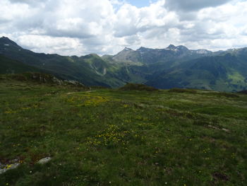 Scenic view of green landscape and mountains against sky