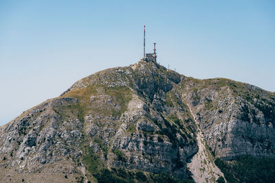 Low angle view of cross on rock against sky