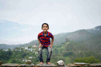 Little indian kid jumping with joy on the roof