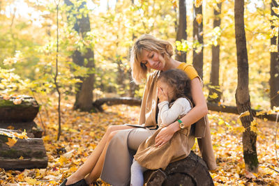 Mother and daughter in park during autumn