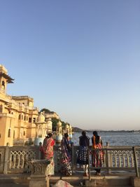 People at beach against clear sky