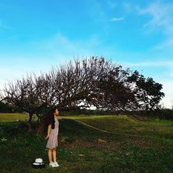 Woman standing on field against sky