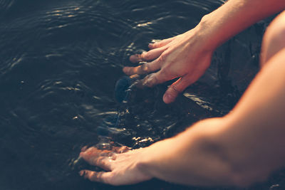 Hands washing diving goggles in water, sweden