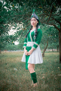 Portrait of a smiling young woman standing on field