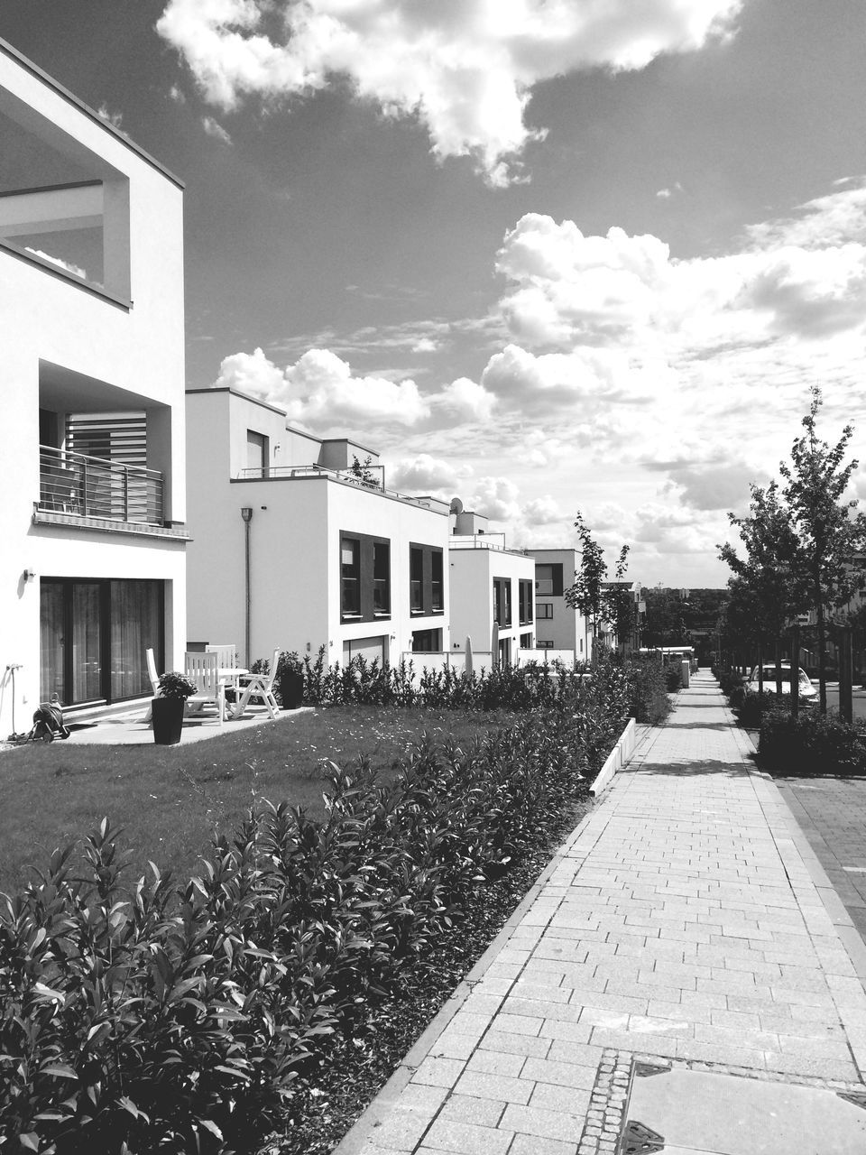 building exterior, architecture, built structure, sky, street, the way forward, cloud - sky, house, transportation, cloud, residential structure, road, residential building, day, cobblestone, building, outdoors, empty, city, cloudy