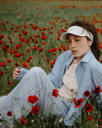 Portrait of young woman standing amidst flowers