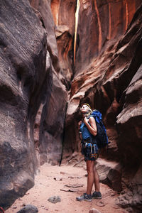 Female hiker looking up while standing amidst rock formations