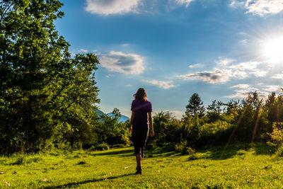 Rear view of man on field against sky