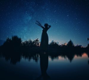 Rear view of woman standing in lake