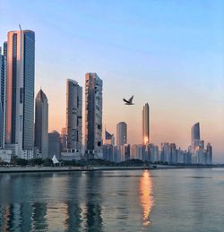 Sea by buildings against sky in city