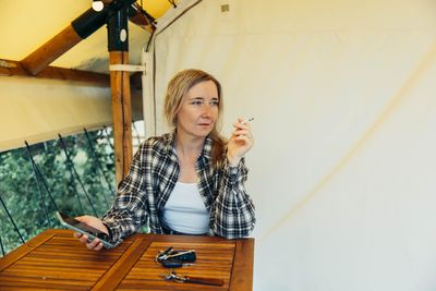 Portrait of young woman standing against wall