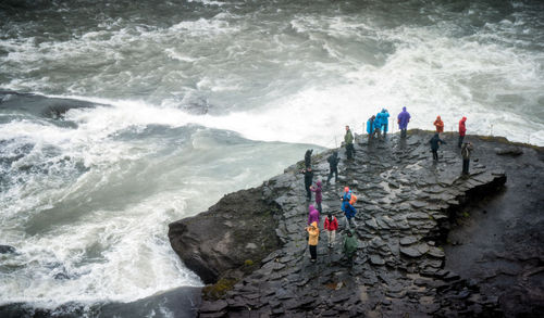 High angle view of people on rock by river