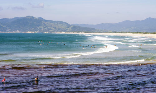 High angle view of people in sea against sky