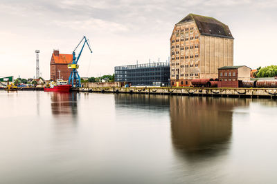 Panoramic view of the commercial harbour of stralsund with cranes, warehouses and tugboat.