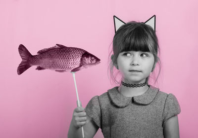 Portrait of woman against pink background