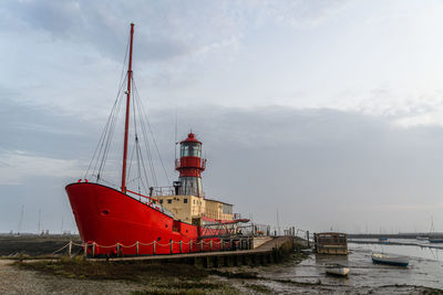 Ship moored at harbor against sky