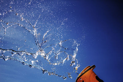 Low angle view of frozen tree against clear blue sky