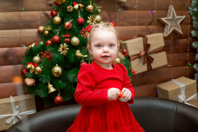 Portrait of cute girl playing with christmas tree