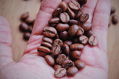 Close-up of hand holding coffee beans