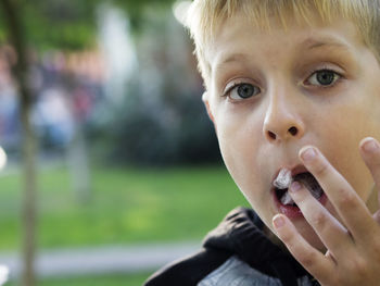 Close-up portrait of boy eating cotton candy