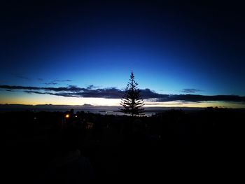 Silhouette trees on field against sky during sunset