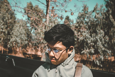 Young man against trees